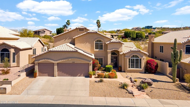 mediterranean / spanish house featuring a tile roof, stucco siding, concrete driveway, an attached garage, and fence