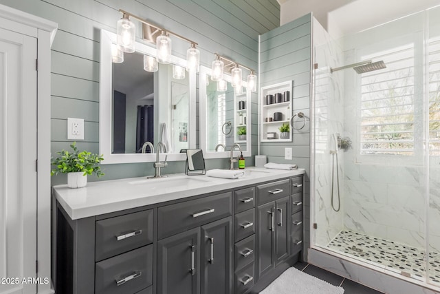 bathroom with a shower with shower door, vanity, tile patterned floors, and wood walls