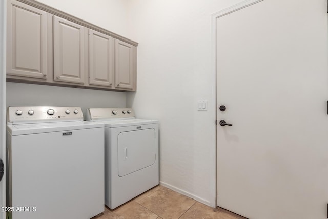 laundry area featuring cabinets, washer and clothes dryer, and light tile patterned flooring