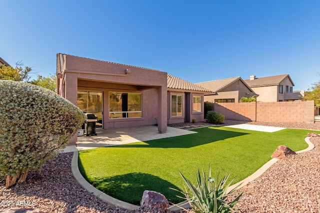 back of house with a patio area and a lawn