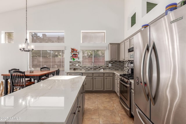 kitchen featuring high vaulted ceiling, stainless steel appliances, and a center island