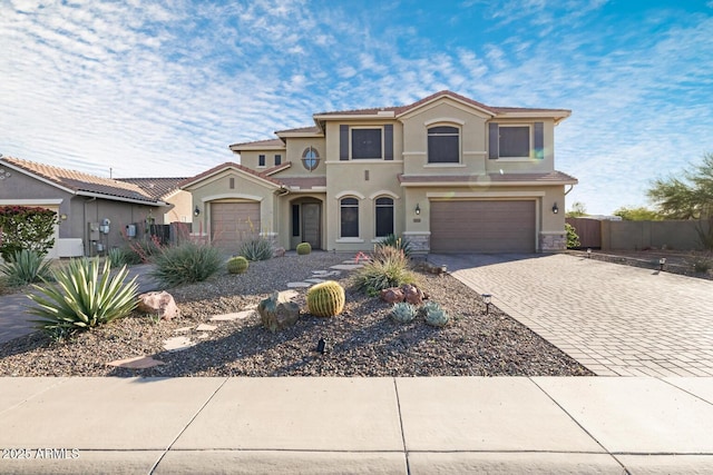 44014 N 49th Dr, New River, AZ 85087 - mediterranean / spanish home featuring fence, stone siding, decorative driveway, stucco siding, and an attached garage