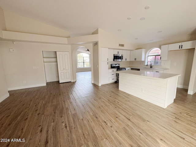 kitchen with white cabinetry, a center island, sink, lofted ceiling, and appliances with stainless steel finishes