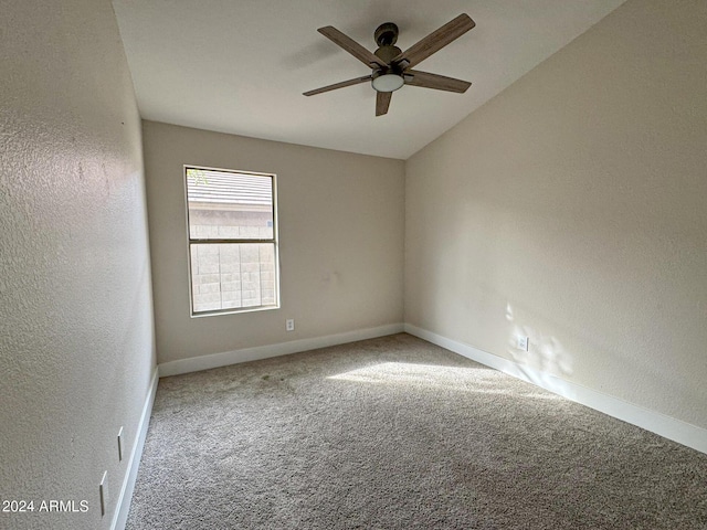 carpeted empty room featuring vaulted ceiling and ceiling fan