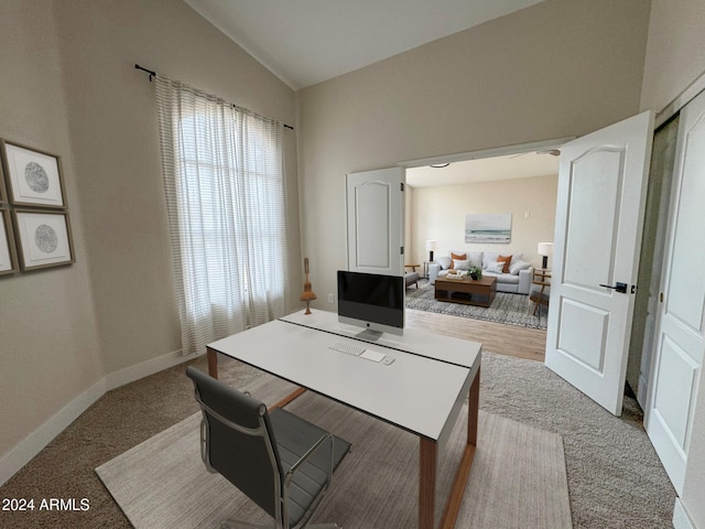 office featuring light carpet and vaulted ceiling