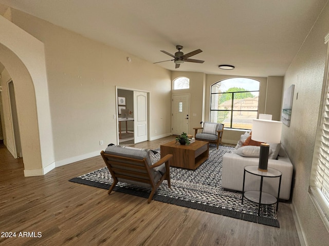 living room with dark hardwood / wood-style flooring and ceiling fan