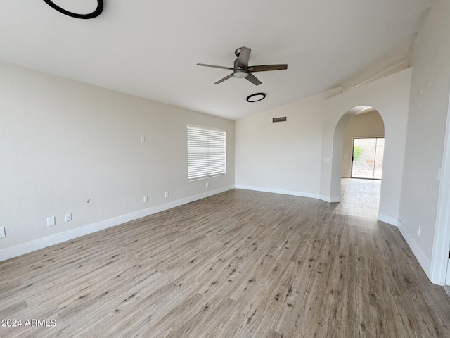 empty room featuring light wood-type flooring, vaulted ceiling, and ceiling fan