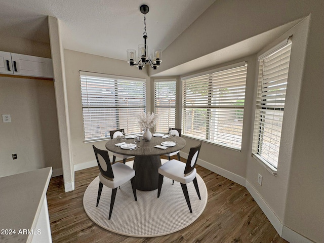 dining area featuring lofted ceiling, dark wood-type flooring, and a notable chandelier