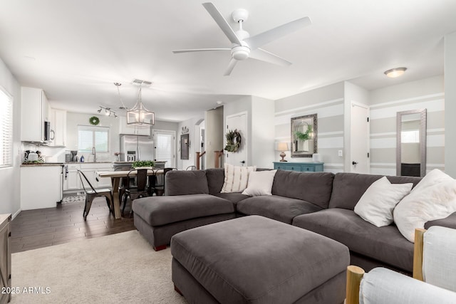 living room featuring ceiling fan, wood finished floors, and visible vents