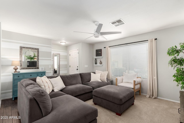 living room featuring baseboards, visible vents, and a ceiling fan