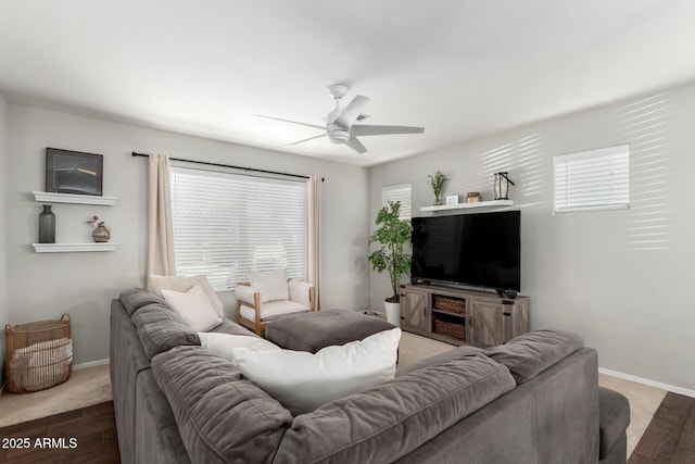 living room with baseboards and a ceiling fan