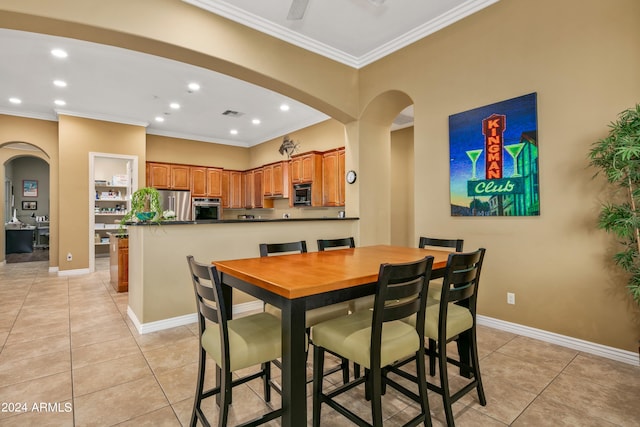 tiled dining area featuring crown molding