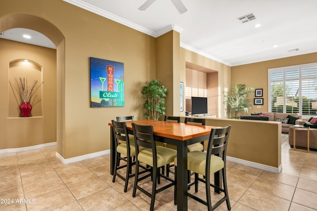 dining area with ceiling fan, light tile patterned floors, and crown molding