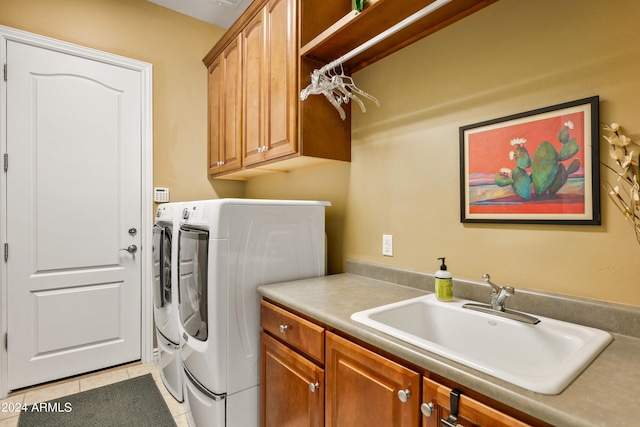 laundry room with cabinets, washing machine and dryer, light tile patterned floors, and sink