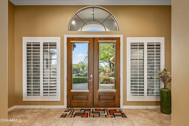 tiled foyer entrance featuring french doors and crown molding