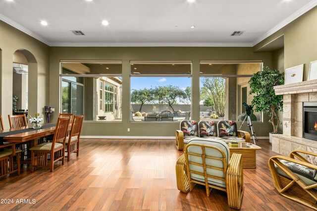 living room with ceiling fan, hardwood / wood-style flooring, ornamental molding, and a high end fireplace