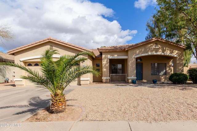 mediterranean / spanish house featuring concrete driveway, a tiled roof, and stucco siding