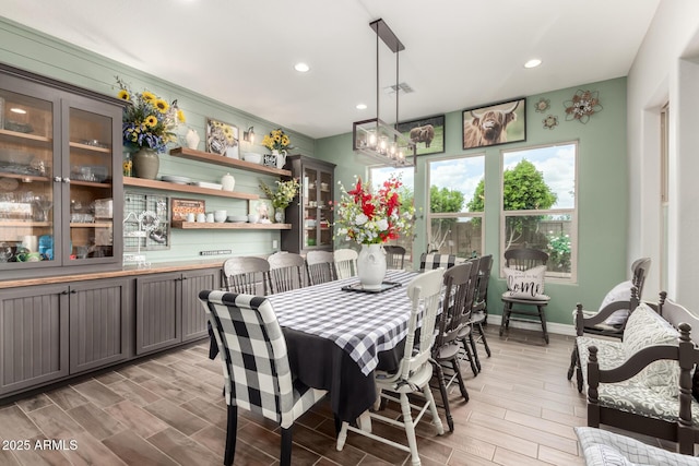dining room featuring wood tiled floor, baseboards, visible vents, and recessed lighting