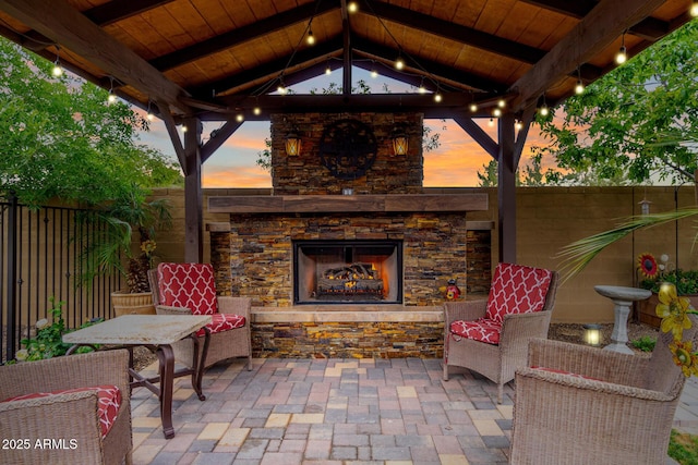 view of patio / terrace featuring a gazebo, an outdoor stone fireplace, and fence