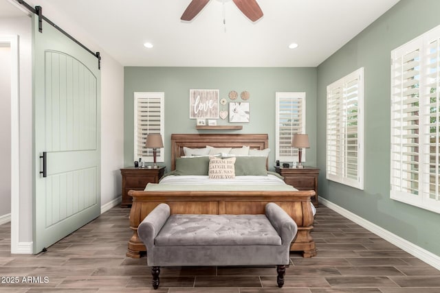 bedroom with baseboards, wood finished floors, recessed lighting, and a barn door
