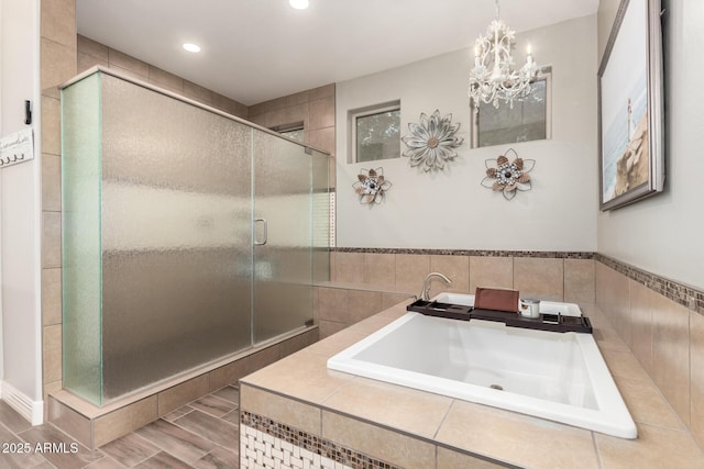 bathroom featuring a garden tub, a sink, a stall shower, a notable chandelier, and recessed lighting