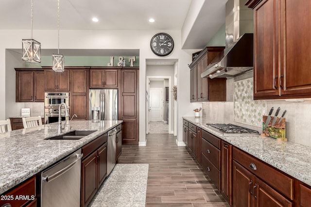 kitchen with stainless steel appliances, a sink, decorative backsplash, wall chimney range hood, and light stone countertops