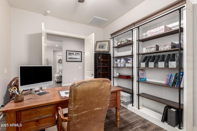 home office featuring wood finished floors, visible vents, and baseboards