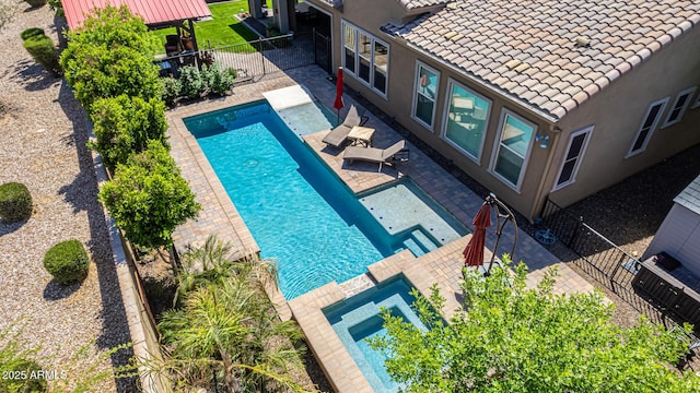 view of swimming pool with a patio area, a fenced backyard, and a pool with connected hot tub