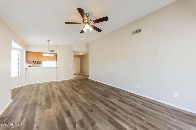 unfurnished living room featuring ceiling fan with notable chandelier and wood-type flooring