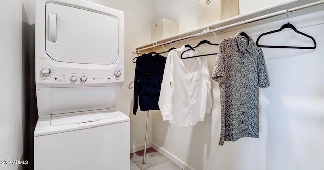 clothes washing area with light tile patterned floors and stacked washer and clothes dryer