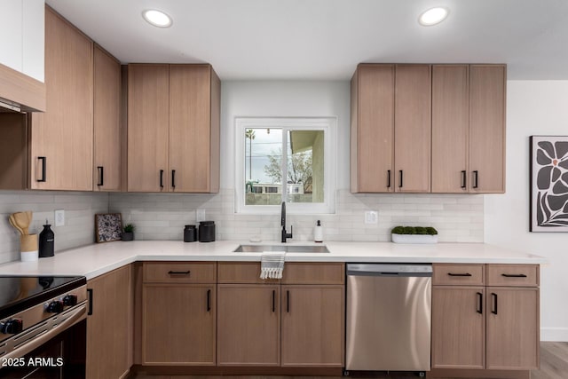 kitchen featuring recessed lighting, a sink, light countertops, appliances with stainless steel finishes, and tasteful backsplash