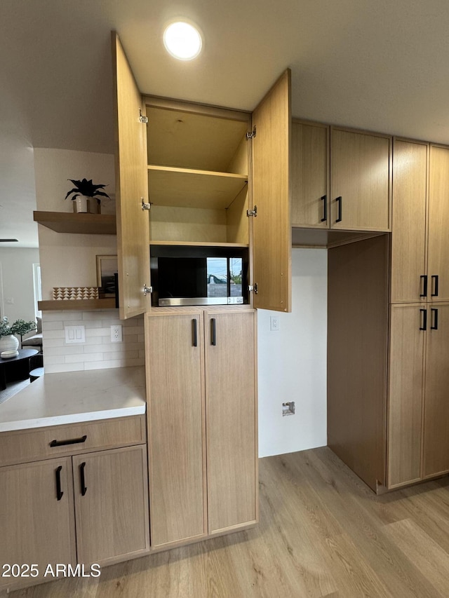 kitchen with open shelves, light countertops, and light brown cabinetry