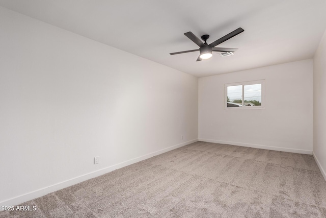 empty room with baseboards, light colored carpet, visible vents, and ceiling fan