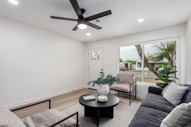 living area featuring a wealth of natural light, recessed lighting, light wood-style flooring, and baseboards