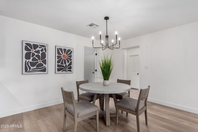 dining area featuring a chandelier, visible vents, baseboards, and light wood-style floors