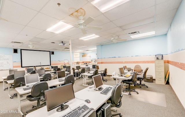 office area with ceiling fan, visible vents, a drop ceiling, and carpet flooring