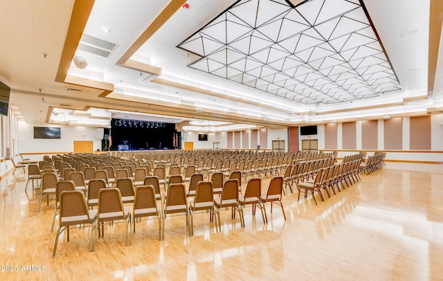 interior space with visible vents, a tray ceiling, and wood finished floors