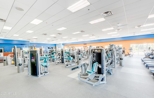 gym with a paneled ceiling and visible vents