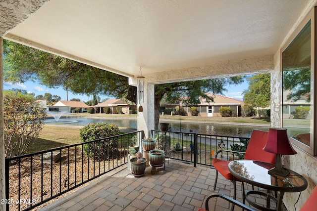 sunroom featuring a water view and a residential view