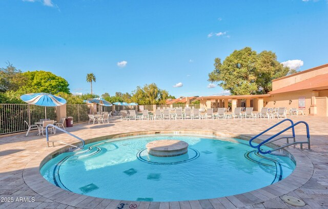 community pool featuring a patio and fence