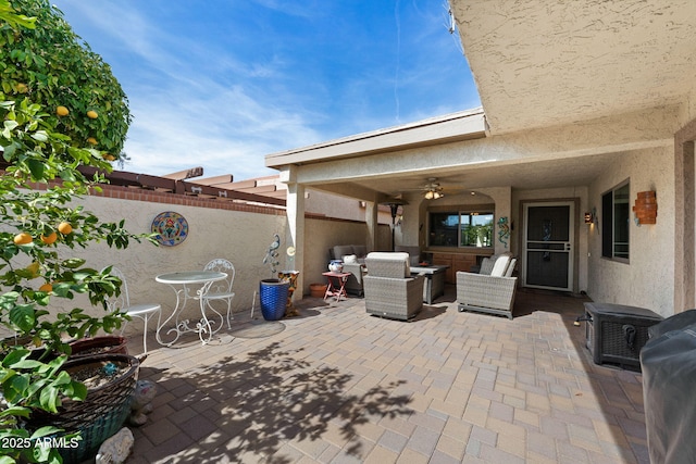view of patio with an outdoor hangout area, a fenced backyard, and a ceiling fan