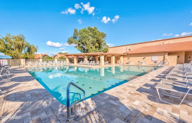 community pool featuring fence and a patio