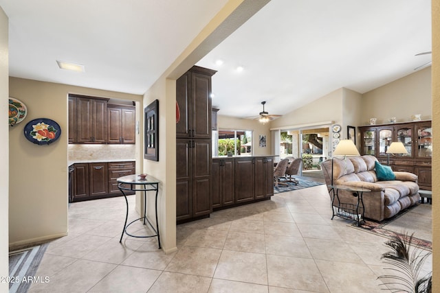 kitchen featuring a breakfast bar area, light tile patterned flooring, dark brown cabinetry, open floor plan, and light countertops