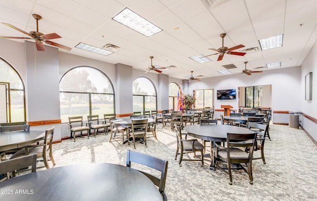 dining space featuring light colored carpet, visible vents, a drop ceiling, and baseboards