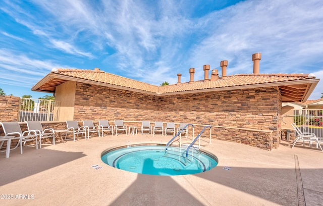 view of swimming pool with a hot tub, fence, and a patio