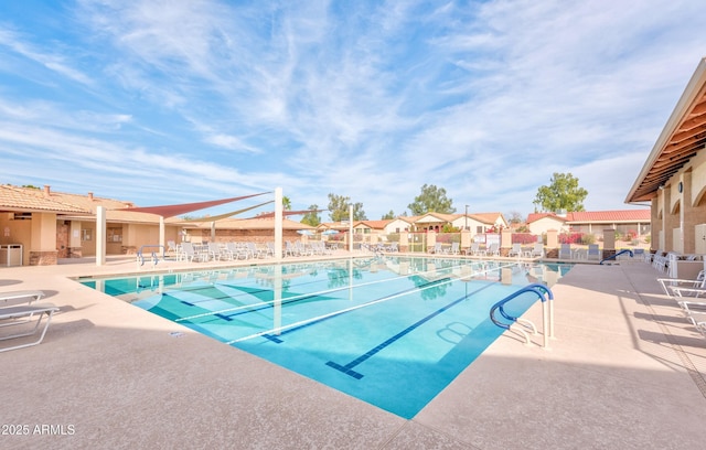 pool with a residential view and a patio area
