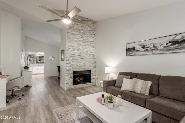 living area featuring a fireplace, light wood-style flooring, ceiling fan, high vaulted ceiling, and baseboards