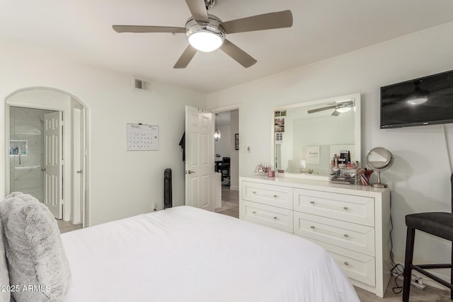 bedroom with ceiling fan, arched walkways, connected bathroom, and visible vents