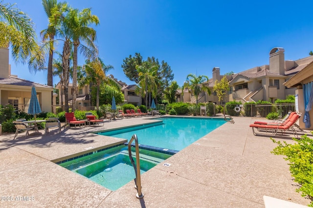 pool featuring a residential view, a patio area, fence, and a hot tub