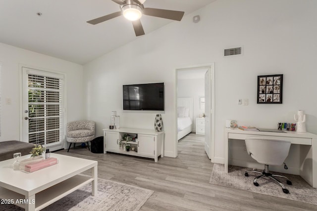 living area featuring lofted ceiling, ceiling fan, light wood finished floors, and visible vents